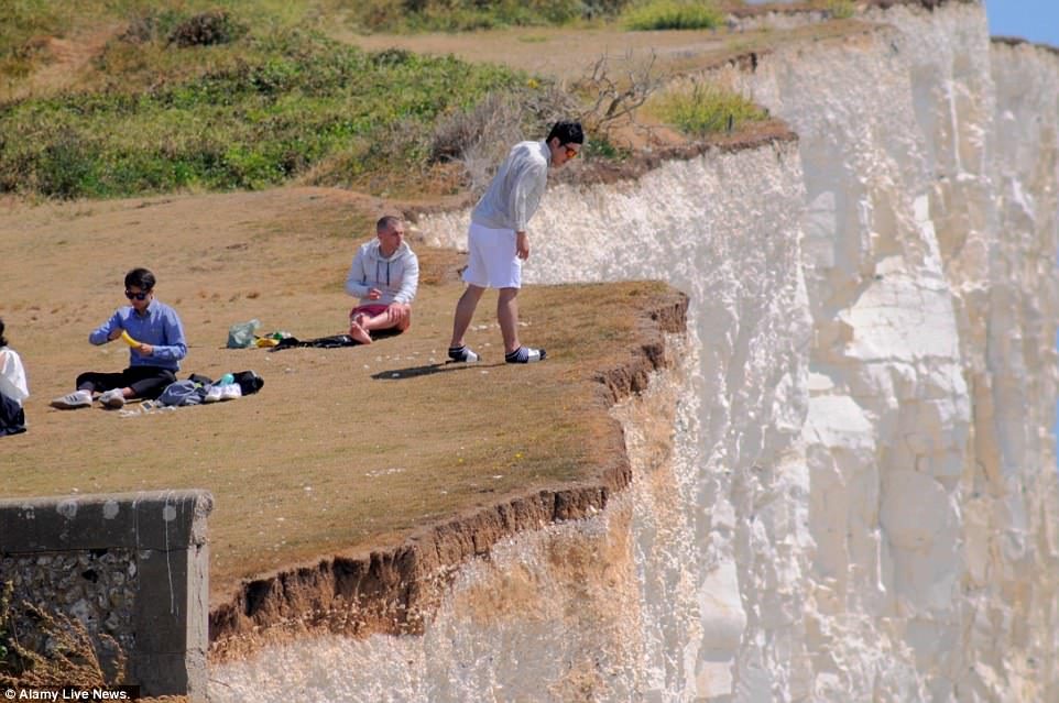 Sightseers were seen looking over the edge and sitting on top of Birling Gap, roughly six miles from Seaford Head
