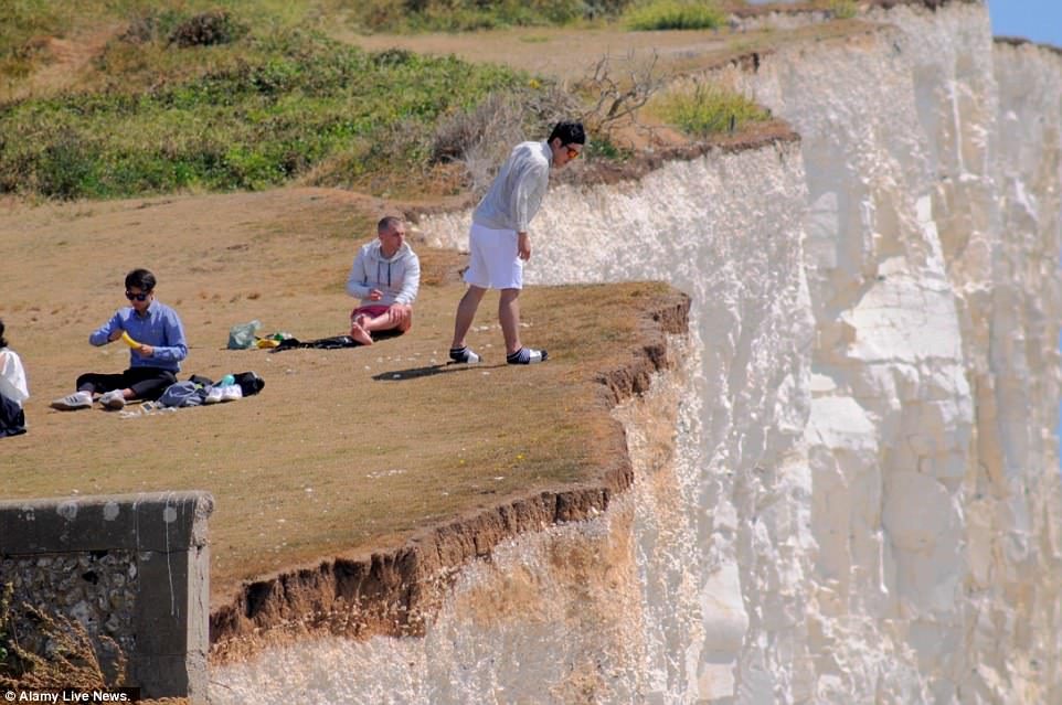 Click to enlarge Sightseers were seen looking over the edge and sitting on top of Birling Gap, roughly six miles from Seaford Head