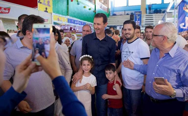 Bashar Al Assad walking around a local Damascus market