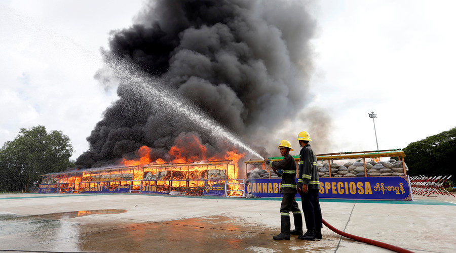 Click to enlarge Firefighters prepare to extinguish fire after burning seized drugs outside Yangon, Myanmar