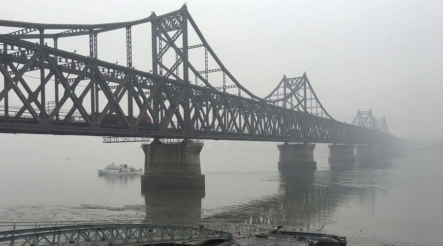 Trucks move across the bridge linking North Korea with the Chinese border city of Dandong