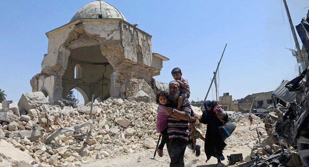 Displaced Iraqi civilians walk past the ruined Grand al-Nuri Mosque after fleeing from the Old city in Mosul, Iraq, June 30, 2017