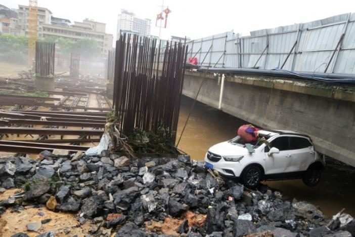 A damaged car is seen under a bridge after a flood in Quanzhou County, in Guilin, Guangxi province, China July 2, 2017.