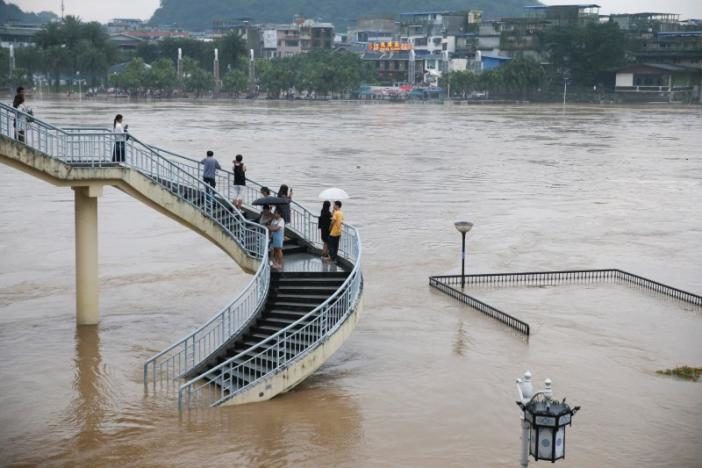 People watch the rising water level of the Li River during a flood in Guilin, Guangxi Zhuang Autonomous Region, China, July 1, 2017.