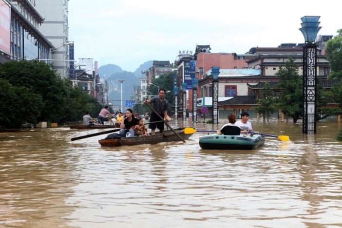 Click to enlarge People make their way with boats through a flooded area in Liuzhou, Guangxi province, China, July 2, 2017.