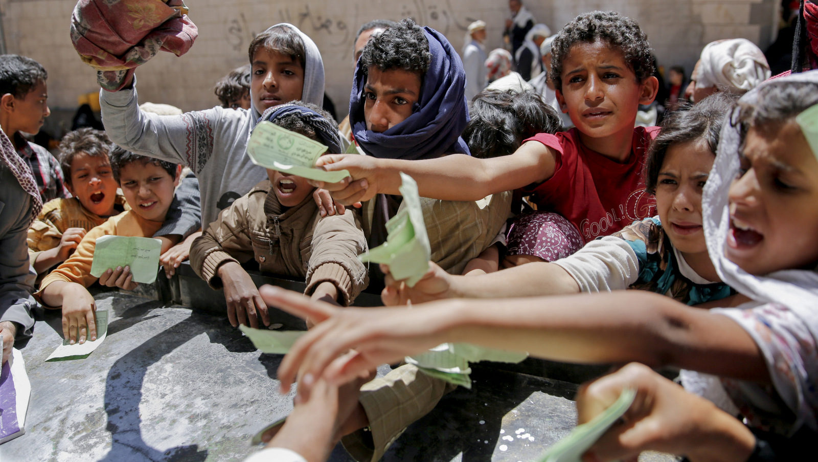 Yemenis present documents in order to receive food rations