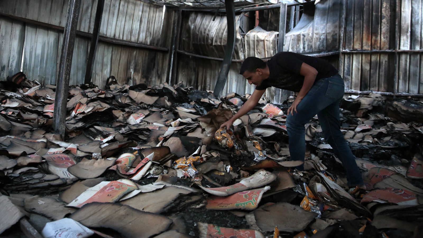 man inspects a food factory hit by Saudi-airstrikes, in Sanaa
