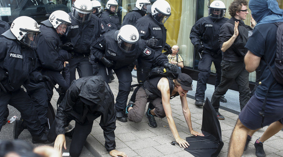 Police officers push away activists who tried to block a street during the G20 summit in Hamburg