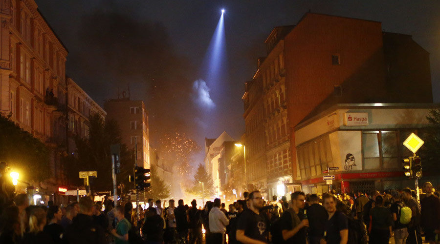 A police helicopter lights a street at anti-G20 protesters
