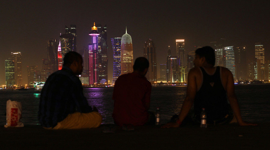 People sit on the corniche in Doha, Qatar