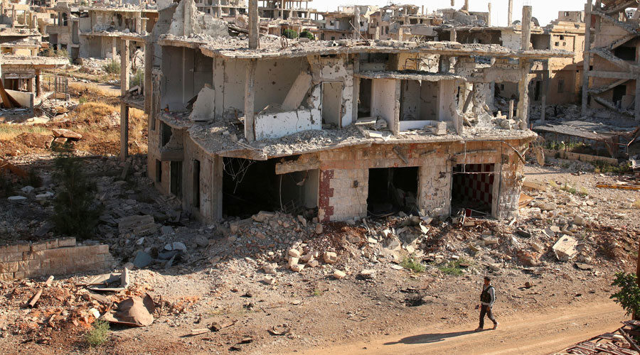 rebel fighter walks past damaged buildings