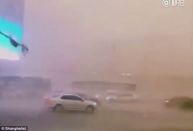 Click to enlarge Car were pushed around by winds as the severe storm battered Chengdu, China, yesterday