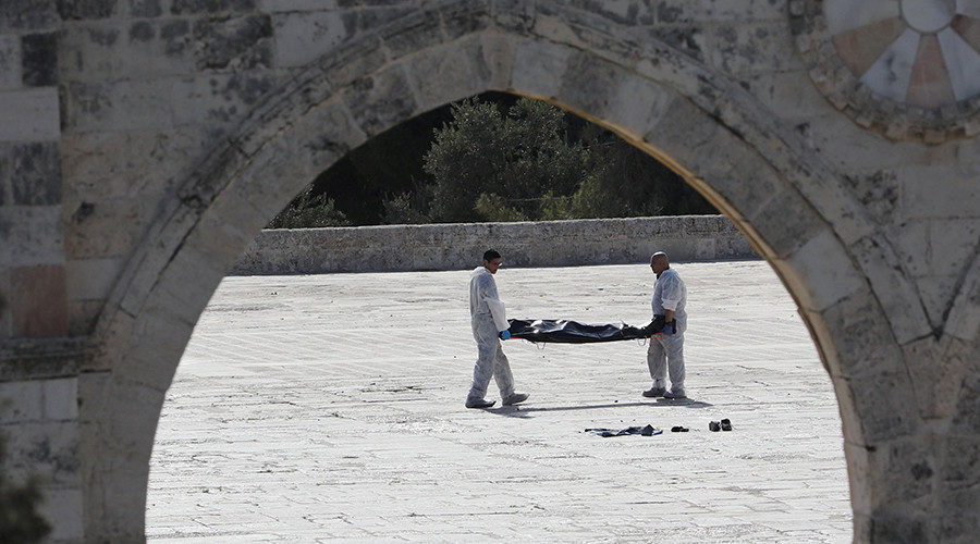 Israeli policemen carry the body of an assailant after he was shot dead