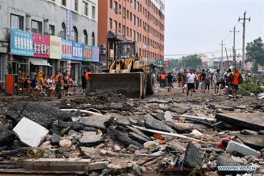 Rescuers repair a damaged road in downtown of Yongji County in Jilin City, northeast China's Jilin Province, July 14, 2017.