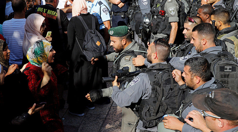 Click to enlarge Palestinian woman argues with an Israeli border policeman
