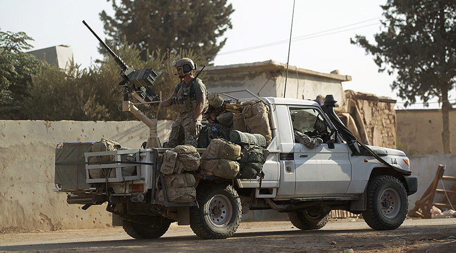 Click to enlarge US soldiers ride a military vehicle