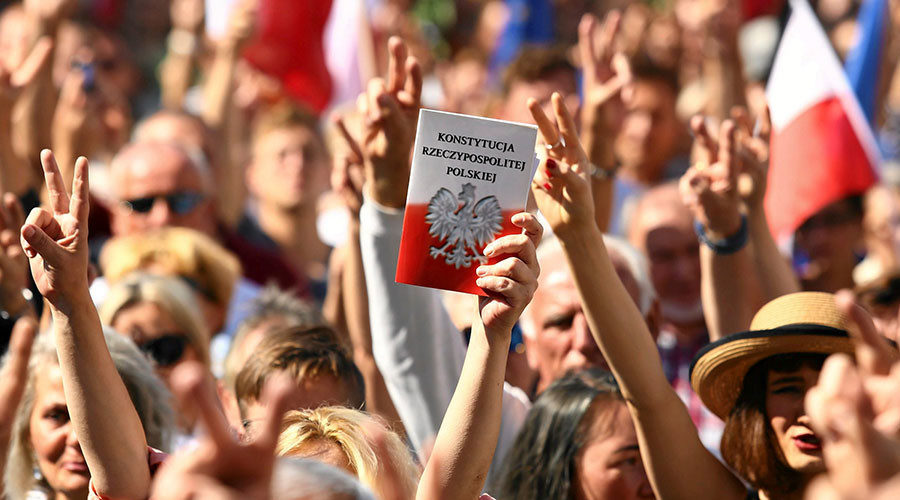 protester holds a copy of the Polish Constitution