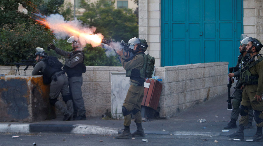 Click to enlarge An Israeli soldier fires a tear gas canister