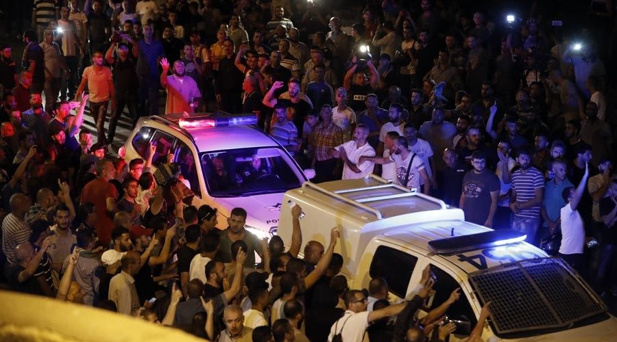 Palestinian demonstrators attempt the block the road ahead of Israeli police cars outside Lions' Gate, a main entrance to the Al-Aqsa mosque compound in Jerusalem's Old City, on July 22, 2017