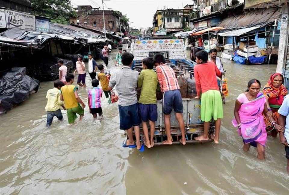 People wade through a flooded street after high tide in river Ganga in Kolkata on Monday.