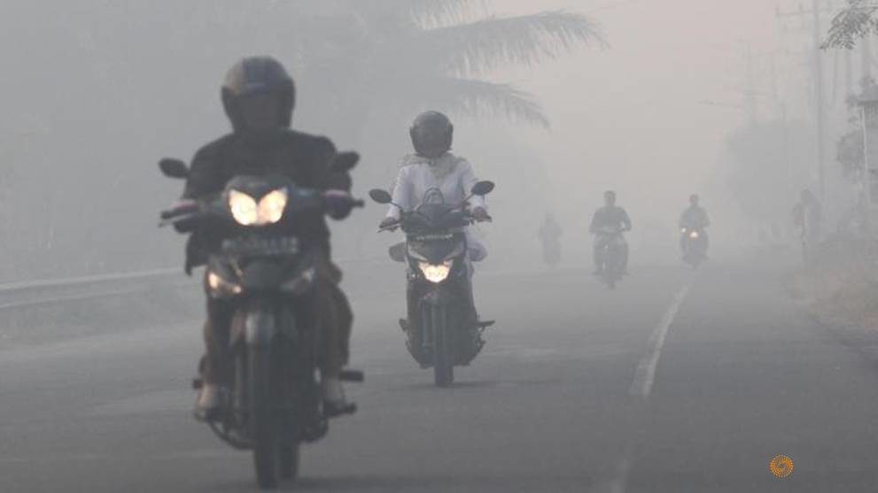 Resident drives motorcycle through haze as peatland fires at Suak Raya village in Aceh Barat, Indonesia Aceh province, Jul 24, 2017