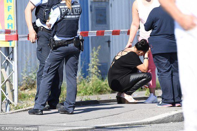 A woman is comforted at the scene as police stand guard next to the Grey nightclub