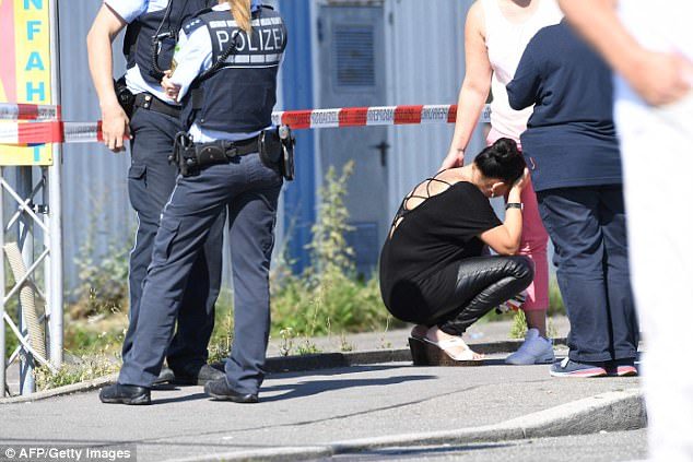 Click to enlarge A woman is comforted at the scene as police stand guard next to the Grey nightclub