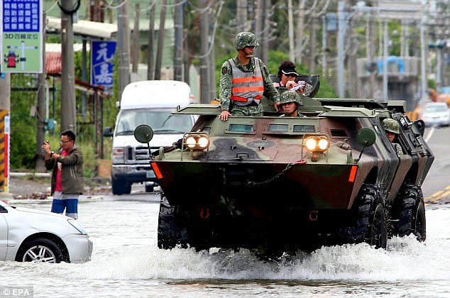 Soldiers were in an amoured vehicle to deliver food and drinking water to people stranded in flooded areas in Pingtung County, southern Taiwan, on Sunday