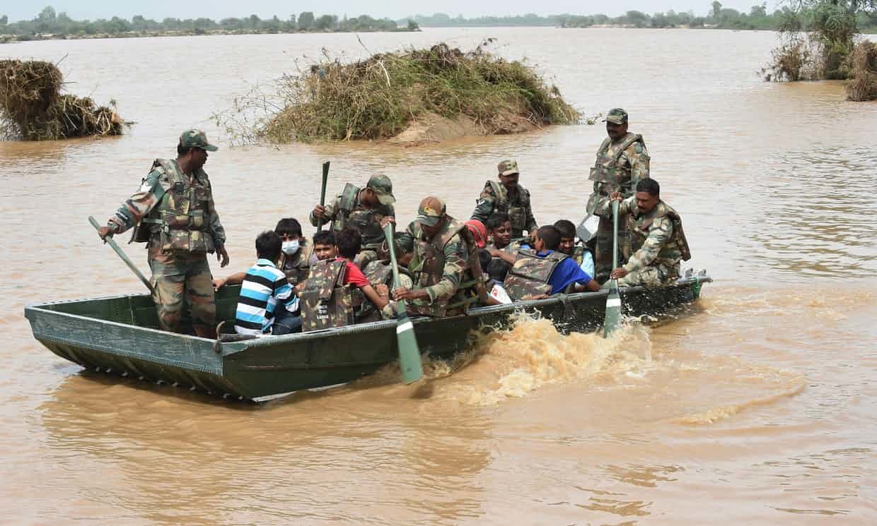 Click to enlarge Soldiers bring to safety stranded flood victims in Khariya village, Gujarat. Photograph: Sam Panthaky