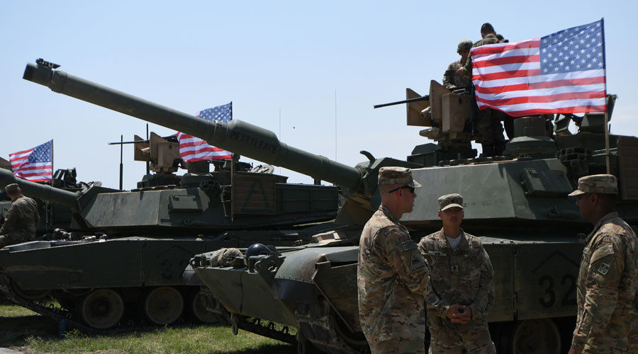 US soldiers stand by Abrams Battle Tanks