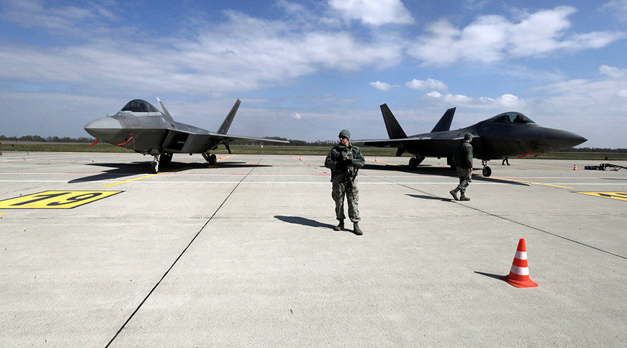 U.S. Army soldiers guard as U.S. Air Force F-22 Raptor fighters