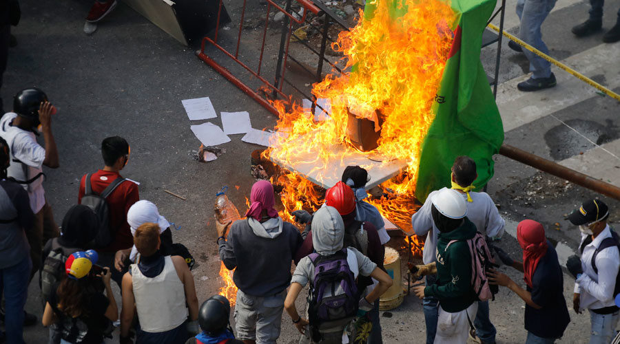 Demonstrators watch a barricade burn after clashes broke out while the Constituent Assembly election is being carried out in Caracas