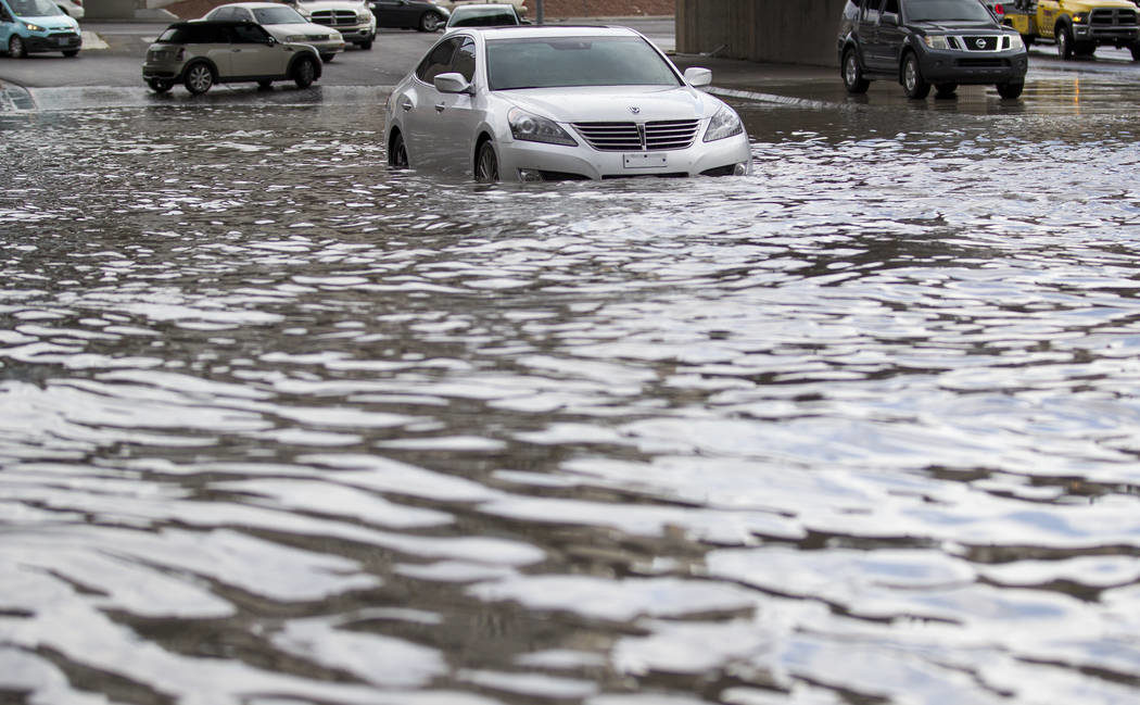 A stalled vehicle sits in flood waters on West Twain Avenue