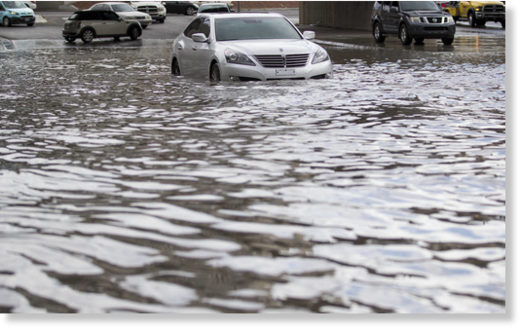 A stalled vehicle sits in flood waters on West Twain Avenue