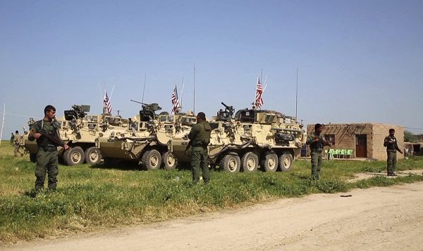 Click to enlarge Kurdish fighters of the People's Protection Units (YPG) standing guard as U.S. forces take up positions