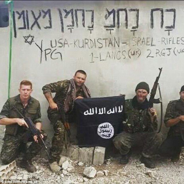 Click to enlarge Robinson is on the far left, holding his weapon while his fellow YPG comrades are holding a Daesh flag