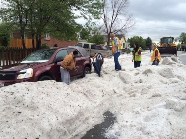 Crews from Denver Public Works help neighbors dig their cars out from several feet of hail
