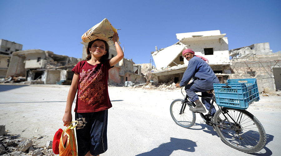 A girl is seen at a damaged site in Aleppo's Sheikh Maqsoud neighbourhood, Syria