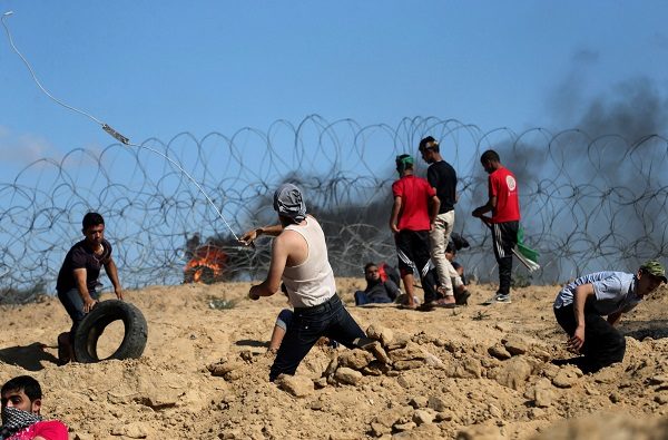 Click to enlarge Palestinian protesters hurl stones at Israeli troops