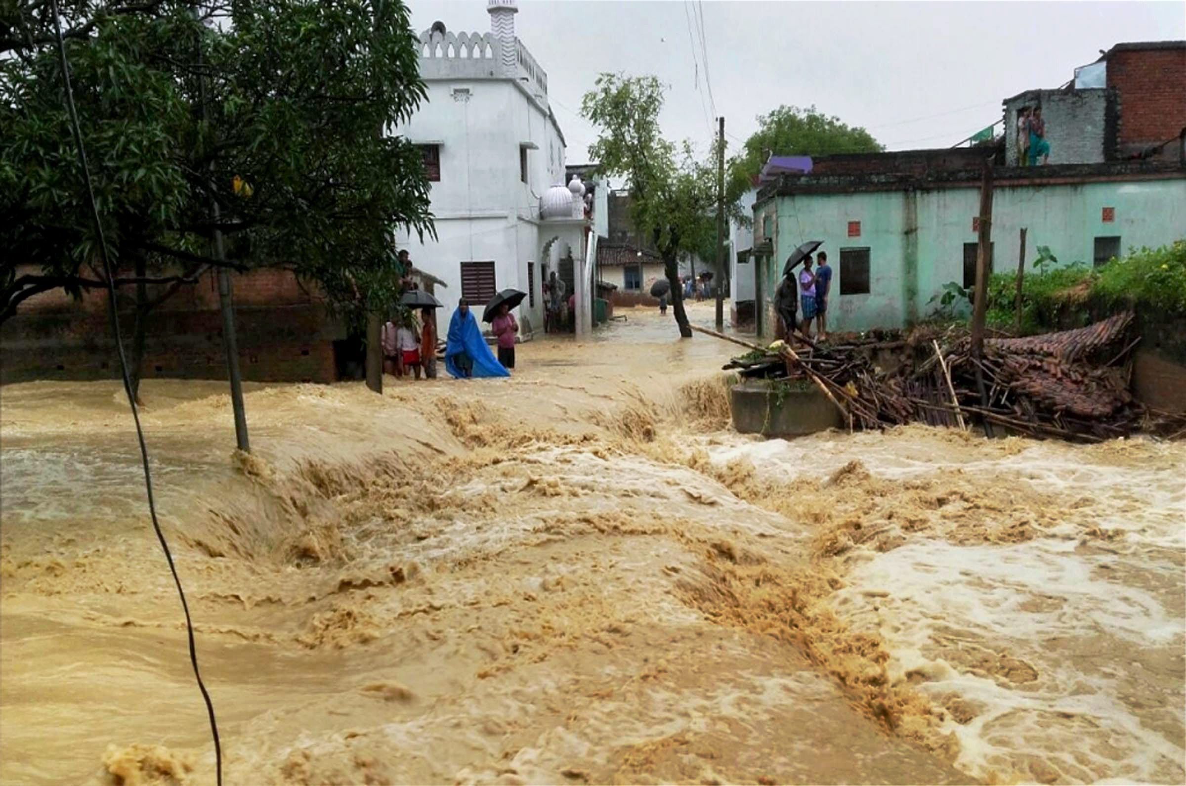 Floodwaters gush through a street in West Champaran, Bihar