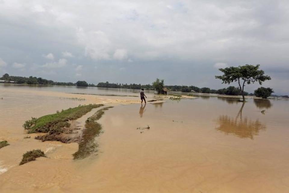 Shrawan Ram, 17, walks through a flooded area to reach his inundated home in Saptari district, Nepal, on August 14, 2017.