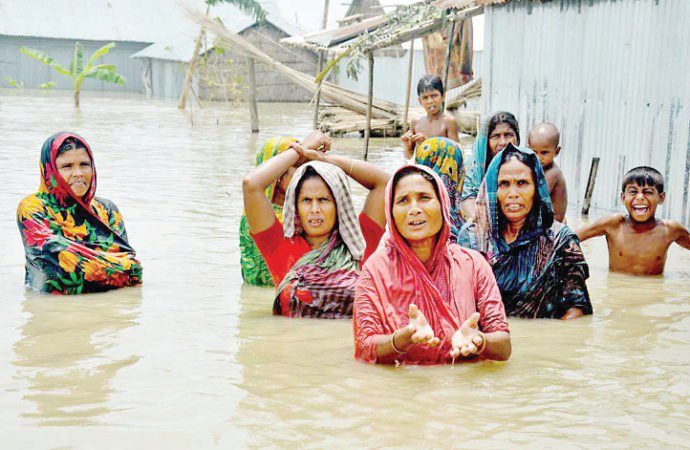 Desperate for help, a group of women and children at Hotathpara village in Fulchhari upazila, Gaibandha wade through chest-high water to get to relief workers on August 16, 2017.