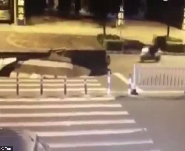 a scooter zoomed into view with the driver so distracted by their mobile phone they didn't see the sinkhole