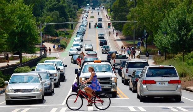 woman riding bicycle in traffic