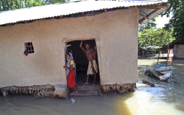 Villagers stand inside their house destroyed by floodwaters at Katihar district, in the eastern Indian state of Bihar, on Saturday 19 August 2017.