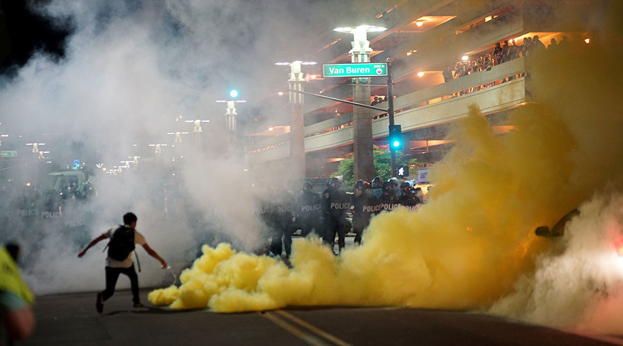 Police officials lob tear gas to try and disperse demonstrators after a Donald Trump campaign rally in Phoenix, Arizona
