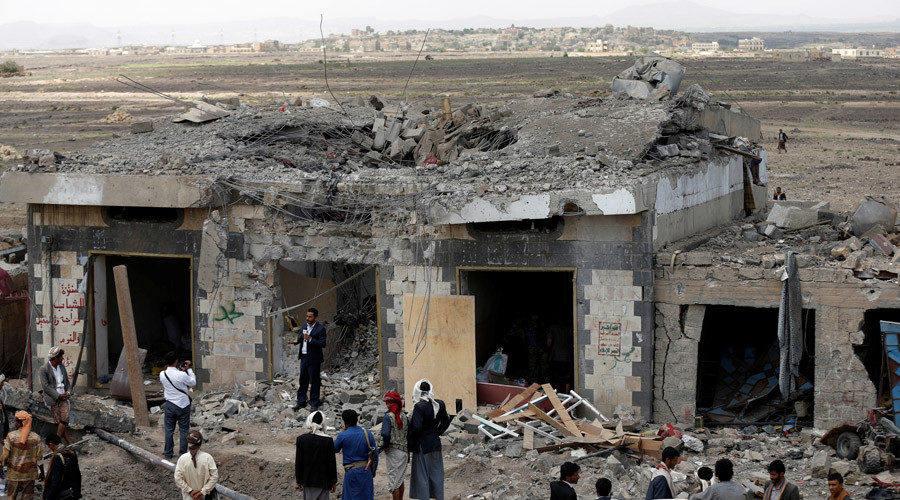 People gather at the site of Saudi-led air strikes in Arhab area, Yemen