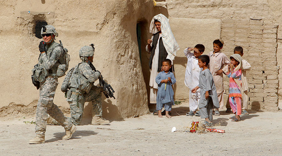 US soldiers secure an area beside Afghan children