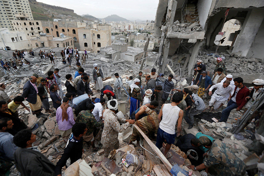 People search under rubble of a house destroyed by a Saudi-led air strike in Sanaa, Yemen