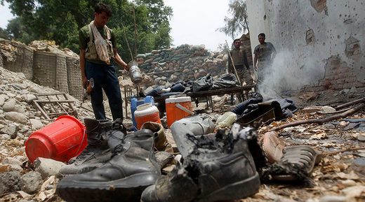 Click to enlarge Afghan policemen inspect a destroyed police checkpoint